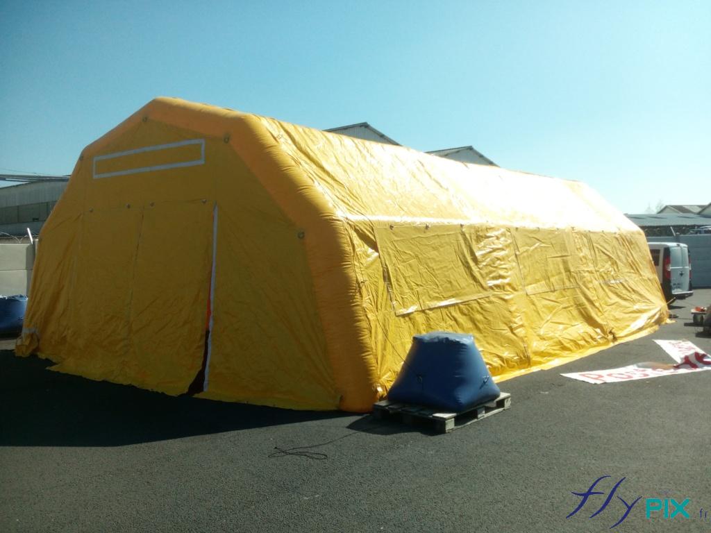 Une tente PMA gonflable de couleur jaune à pans coupés, air captif, gonflé à l'air. Structure étanche en air captif gonflée à l'air avec une pompe électrique 220V, Enveloppe toiture et murs: PVC 0,6 mm, simple cloison, Couleur enveloppe: voir nuancier Pantone pour les couleurs, Charpente : ossatures PVC 0,6 mm, boudins D = 0,90 m simple cloison, Anneaux de fixation métalliques + cordes pour haubanage Lancelin, Normes anti-feu (type M2), normes CE, Valve de suppression, Manchons à air chaud/froid (clim non fournie), 1 bâche au sol en PVC soudée, Bon à tirer, Kit réparation,SAV, Garantie 1 an constructeur - SAV, Fabrication sur mesure en France par nos soins, Tente gonflable réutilisable.