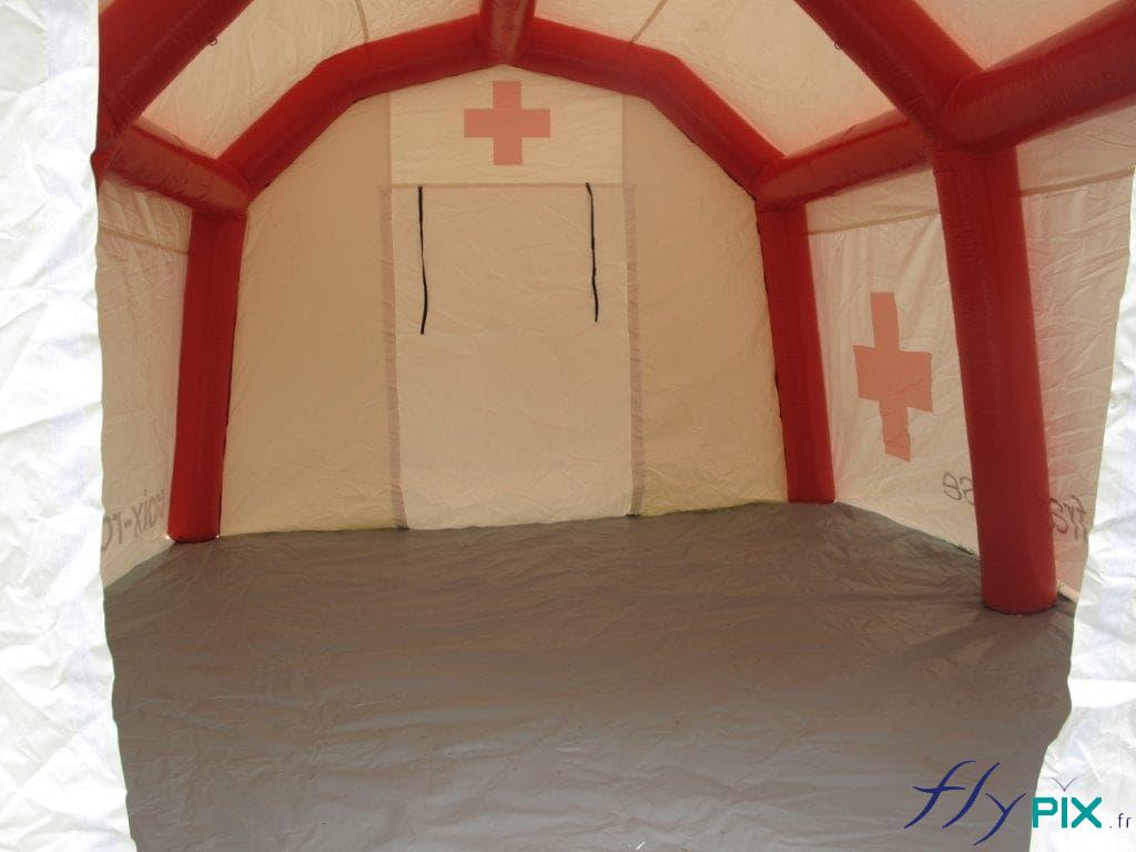 La tente médicale fermée a une bâche au sol, ici la porte est fermée