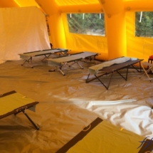 Lits picots installés à l&#039;intérieur d&#039;une tente PMA de grande taille.