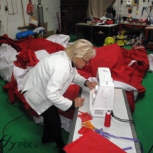 Une technicienne réalise une réparation sur une toile d'enveloppe de tente PMA