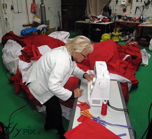 Une technicienne réalise une réparation sur une toile d'enveloppe de tente PMA Une technicienne réalise une réparation sur une toile d'enveloppe de tente PMA