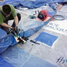Technicien effectuant la réparation d&#039;un mur d&#039;une tente médicale de grande taille.