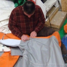 Un technicien est entrain de réparer l&#039;enveloppe d&#039;un mur d&#039;une tente PMA