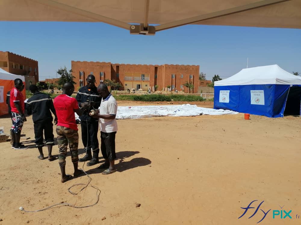 Des techniciens de la Protection Civile sont entrains de vérifier le matériel, pour la pose et l'installation de tentes médicales.