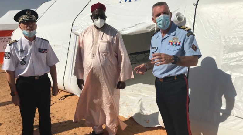 Des officiers et des officiels posent devant une tente médicale gonflable, de grande dimension, air captif.