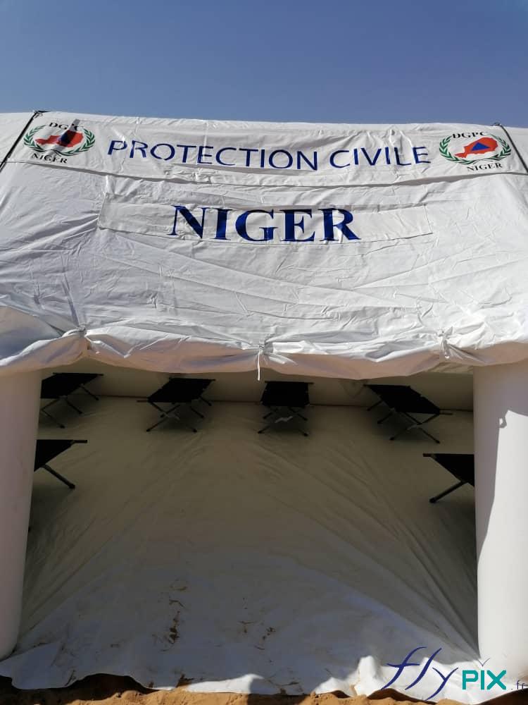 Au dessus de la porte de la tente PMA: des larges banderoles imprimées fixées par du velcro.