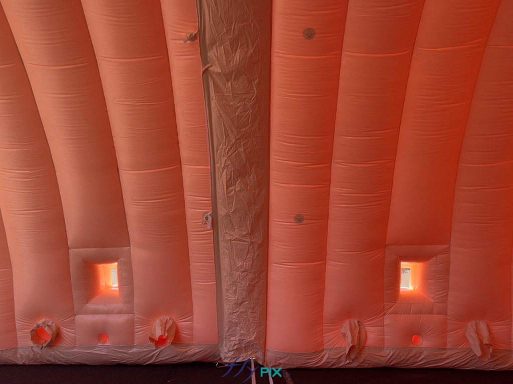 Sur cette photo, 2 modules sont assemblés et jointés, avec les fenêtres transparentes et les volets pliables et amovibles, qui permettent de disposer d'une source de lumière naturelle à l'intérieur d'un module de hangar gonflable. Dans les parties inférieures des modules gonflables, nous voyons les manchons à air et les trous passe fils et gaines électriques. - Copyright : Vivien LAÏLLE/FLYPIX, droits réservés. Sur cette photo, 2 modules sont assemblés et jointés, avec les fenêtres transparentes et les volets pliables et amovibles, qui permettent de disposer d'une source de lumière naturelle à l'intérieur d'un module de hangar gonflable. Dans les parties inférieures des modules gonflables, nous voyons les manchons à air et les trous passe fils et gaines électriques. - Copyright : Vivien LAÏLLE/FLYPIX, droits réservés.