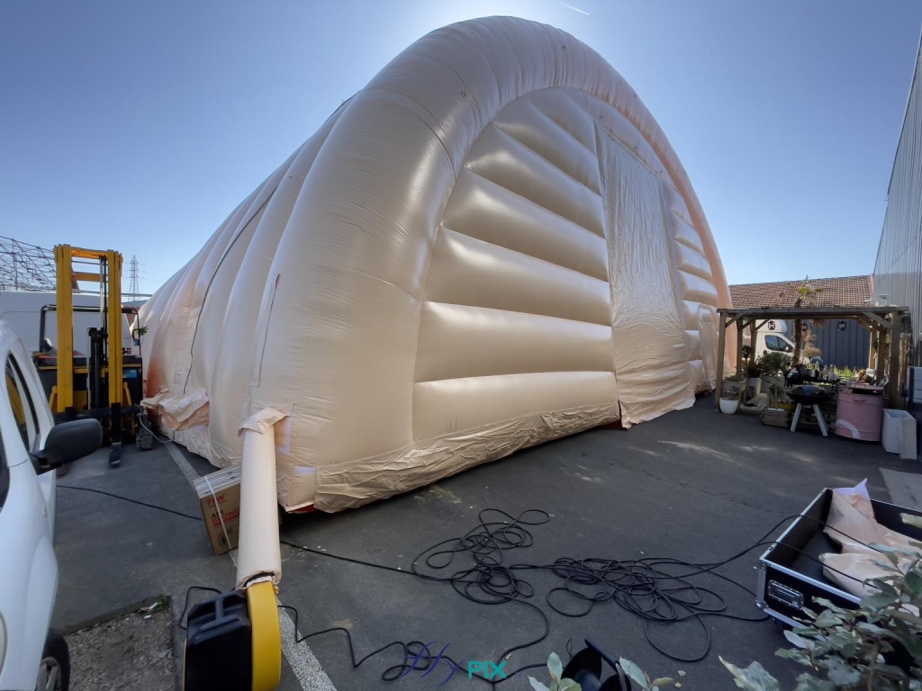 Le hangar gonflable militaire en enveloppe PVC 0.45 mm double peau capitonnée est gonflé avec de l'air grâce à une turbine électrique, visible en bas à gauche sur cette photographie. De l'air est envoyé dans la structure gonflable grâce à un manchon à air fixé à la turbine. Cette photo montre bien le procédé, la turbine doit envoyer de l'air en permanence dans les boudins d'ossatures et dans les murs de l'abri gonflable. - Copyright : Vivien LAÏLLE/FLYPIX, droits réservés. Le hangar gonflable militaire en enveloppe PVC 0.45 mm double peau capitonnée est gonflé avec de l'air grâce à une turbine électrique, visible en bas à gauche sur cette photographie. De l'air est envoyé dans la structure gonflable grâce à un manchon à air fixé à la turbine. Cette photo montre bien le procédé, la turbine doit envoyer de l'air en permanence dans les boudins d'ossatures et dans les murs de l'abri gonflable. - Copyright : Vivien LAÏLLE/FLYPIX, droits réservés.