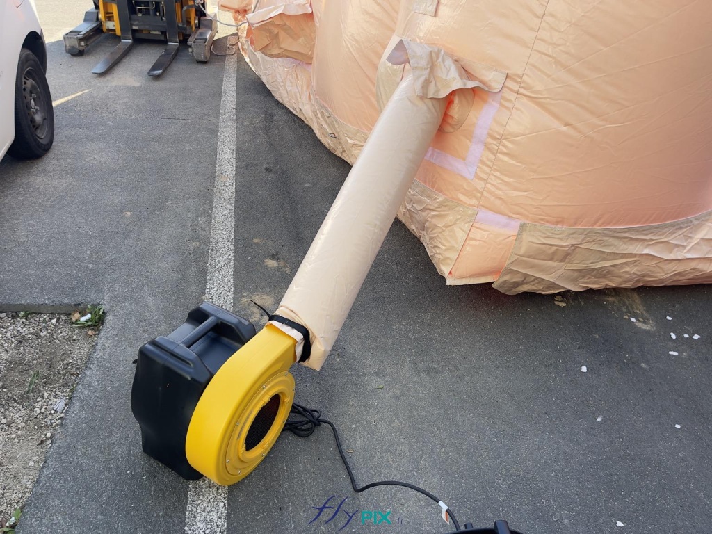 Une vue détaillée de la turbine et du manchon à air qui envoie de l'air dans la structure gonflable, en permanence. Cette turbine électrique fait une puissance de 2500 W environ. Il faut idéalement plusieurs turbines pour gonfler la structure gonflable. - Copyright : Vivien LAÏLLE/FLYPIX, droits réservés. Une vue détaillée de la turbine et du manchon à air qui envoie de l'air dans la structure gonflable, en permanence. Cette turbine électrique fait une puissance de 2500 W environ. Il faut idéalement plusieurs turbines pour gonfler la structure gonflable. - Copyright : Vivien LAÏLLE/FLYPIX, droits réservés.