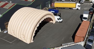 Sur cette photo aérienne prise pendant une phase de test de gonflage et de mise en pression avant expédition de la marchandise vers le commanditaire, vous pouvez contempler 2 modules tunnels demi-lunes assemblés et raccordés faisant partie d'un grand hangar gonflable militaire de grande taille, composé en tout de 5 modules. Ici, nous avons gonflé le module du pignon avant et un module intermédiaire. Ce hangar gonflable militaire mobile, à usages polyvalents, de grande largeur et de grande hauteur, protège du matériel et des hommes des intempéries en temps de guerre, et elle sera déployée sur des terrains d'opérations militaires en zone de conflits armés, pour l'accueil de soldats, de militaires, de parachutistes, d'officiers, et aussi pour stocker du matériel, des véhicules militaires, des engins militaires, des chars de combat, ou des avions, hélicoptères... Cette structure gonflable, fabriquée sur mesure par nos soins, dans nos ateliers en France, à Orléans, est gonflée à l'air grâce à plusieurs turbines électriques, en permanence. L'abri gonflable est entièrement en enveloppe PVC 0.45 mm double peau capitonnée, et dotés de grandes portes, de fenêtres, et d'interfaces utiles comme dans manchons à air pour le contrôle du climat à l'intérieur de la tente gonflable, et des manchons passes fils électriques, de portes de service et d'accès annexes pour le personnel militaire.. - Copyright : Vivien LAÏLLE/FLYPIX, droits réservés.