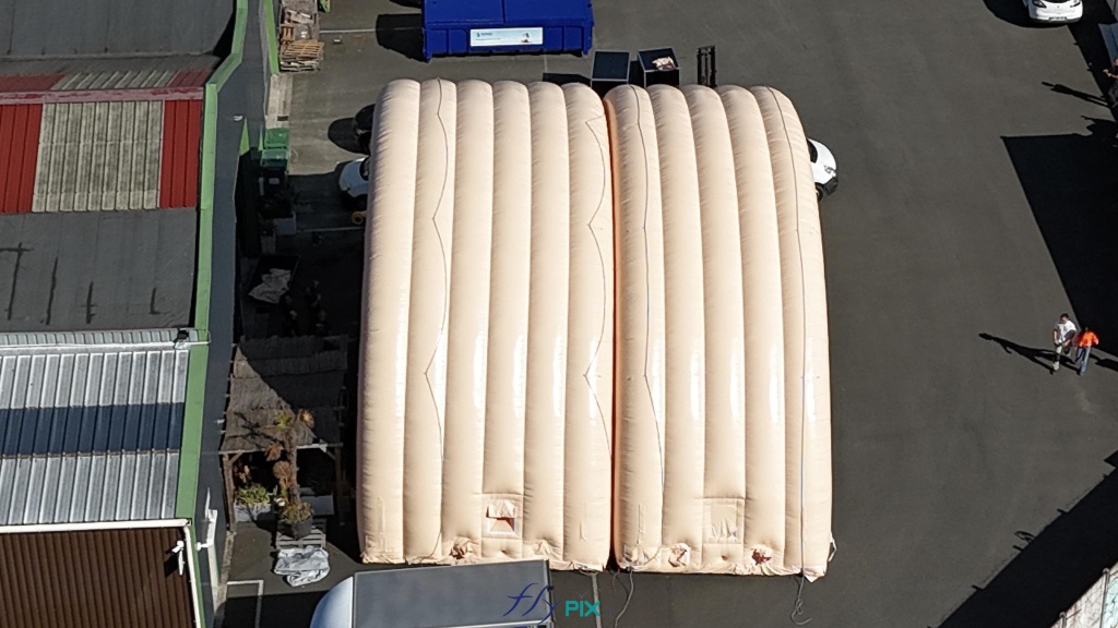 En réalité, très souvent, une longueur d'abri gonflable est décomposée en plusieurs modules gonflables ou unités qui sont raccordés dans le sens de la longueur et assemblés, jointés entre eux. Dans cet exemple, nous voyons 2 modules, mais en fait il y en a 5 en tout. L'autre avantage est que la surface utile intérieure peut être modulée et différente entre telle ou telle opération militaire ; il est même possible de les utiliser simultanément sur 2 sites géographiques différents, au choix, en hangar ouvert ou bien fermé avec pignon avant / arrière ; une solution qui procure une très grande polyvalence sur le terrain. — Copyright : Vivien LAÏLLE/FLYPIX, droits réservés. En réalité, très souvent, une longueur d'abri gonflable est décomposée en plusieurs modules gonflables ou unités qui sont raccordés dans le sens de la longueur et assemblés, jointés entre eux. Dans cet exemple, nous voyons 2 modules, mais en fait il y en a 5 en tout. L'autre avantage est que la surface utile intérieure peut être modulée et différente entre telle ou telle opération militaire ; il est même possible de les utiliser simultanément sur 2 sites géographiques différents, au choix, en hangar ouvert ou bien fermé avec pignon avant / arrière ; une solution qui procure une très grande polyvalence sur le terrain. — Copyright : Vivien LAÏLLE/FLYPIX, droits réservés.