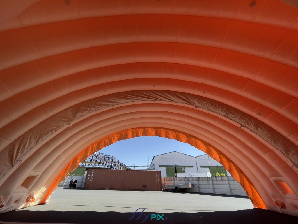 Le hangar gonflable est composé en tout de 5 modules, qui une fois connectés, assembles et jointés procurent un très grand volume et une très grande surface de travail. La hauteur utile est haute et la largeur utile conséquente, ce qui permet une grande polyvalence en ce qui concerne l'utilisation de ce hangar gonflable militaire. Aussi les modules gonflables peuvent être agencés avec ou sans les pignons, sur 1 ou plusieurs sites militaires, en fonction des besoins opérationnels sur le terrain. - Copyright : Vivien LAÏLLE/FLYPIX, droits réservés. Le hangar gonflable est composé en tout de 5 modules, qui une fois connectés, assembles et jointés procurent un très grand volume et une très grande surface de travail. La hauteur utile est haute et la largeur utile conséquente, ce qui permet une grande polyvalence en ce qui concerne l'utilisation de ce hangar gonflable militaire. Aussi les modules gonflables peuvent être agencés avec ou sans les pignons, sur 1 ou plusieurs sites militaires, en fonction des besoins opérationnels sur le terrain. - Copyright : Vivien LAÏLLE/FLYPIX, droits réservés.