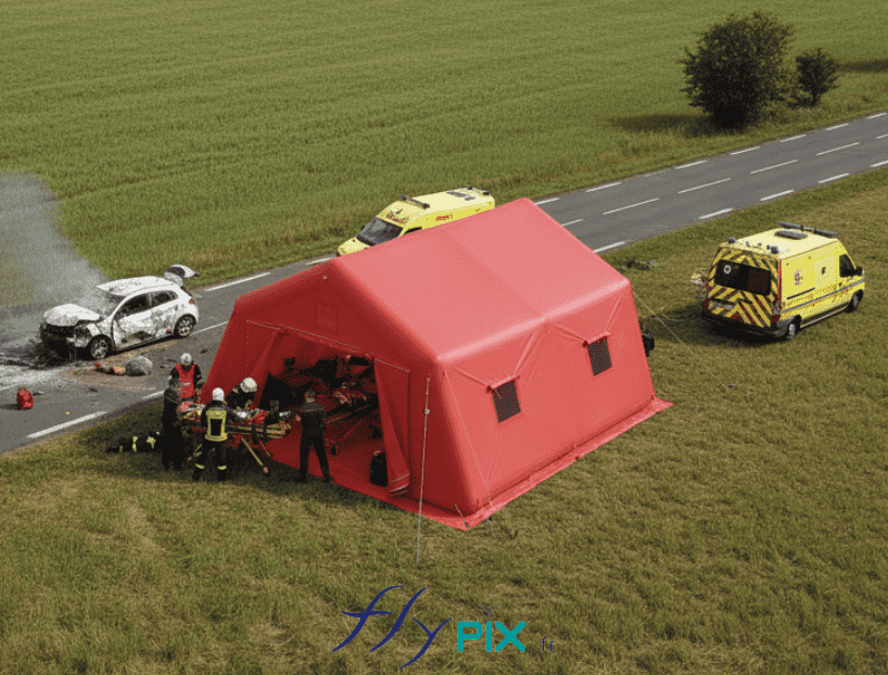 Cette vue aérienne est une simulation présentant le concept d'une intervention en campagne d'unn abri gonflable poste médical avancé, pour la mise en oeuvre de premiers soins et de secours d'urgence, ici à l'occasion d'un accident de la route. La tente gonflable médicale a été fabriquée sur mesure par nos soins, dans nos ateliers en France à Orléans. Il s'agit ici d'un abri gonflable médical d'une surface utile de 37 m2, en forme de pans coupés. Il est air captif, avec des boudins d'ossatures étanches, c'est à dire qu'il est gonflé à l'air avec une pompe électrique. Cette strucure gonflable est autoportée et elle se gonfle d'un seul coup, d'un seul tenant. Elle peut être déployée en cas d'urgence sur n'importe quel site en quelques minutes. - Cette image a été générée par IA, grâce à GEMINI, à partir des vues de modélisations en 3D du BAT (bon à tirer) créées par notre infographiste et validées par le commanditaire, et aussi à partir de photos et de prises de vues réelles de certains détails de la tente gonflable, prises directement dans notre atelier de fabrication. Média partiellement généré par une IA et vérifié par un agent. - Copyright Vivien LAÏLLE/FlyPix, droits réservés, reproduction interdite.