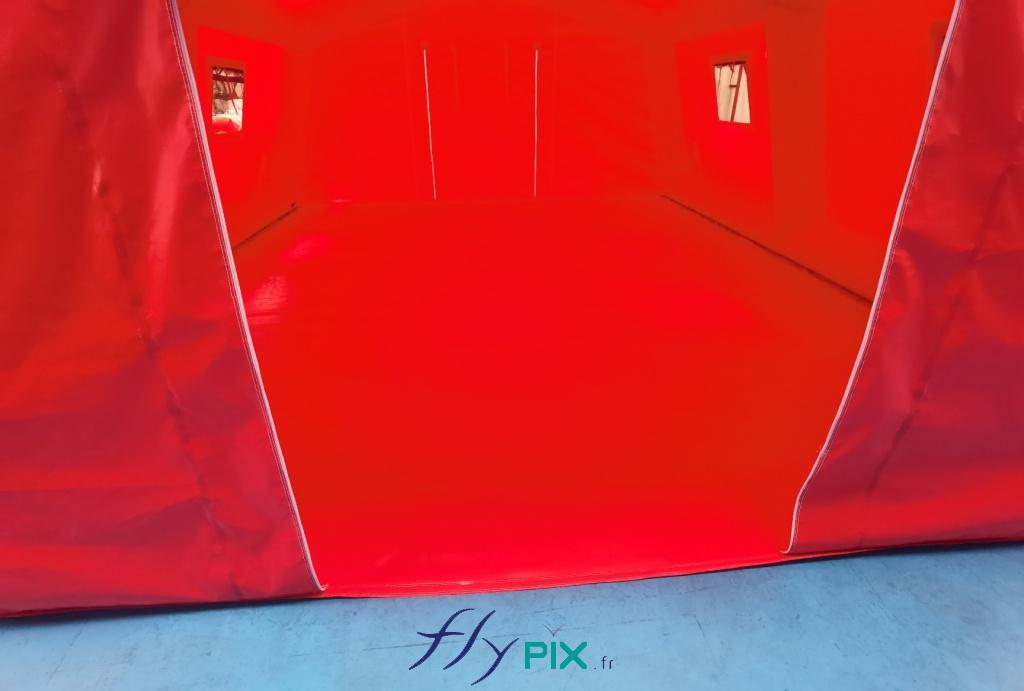 Cette photo montre la porte d'accès principale de l'abri gonflable PMA, avec la bâche au sol. - Copyright Vivien LAÏLLE/FlyPix, droits réservés, reproduction interdite.